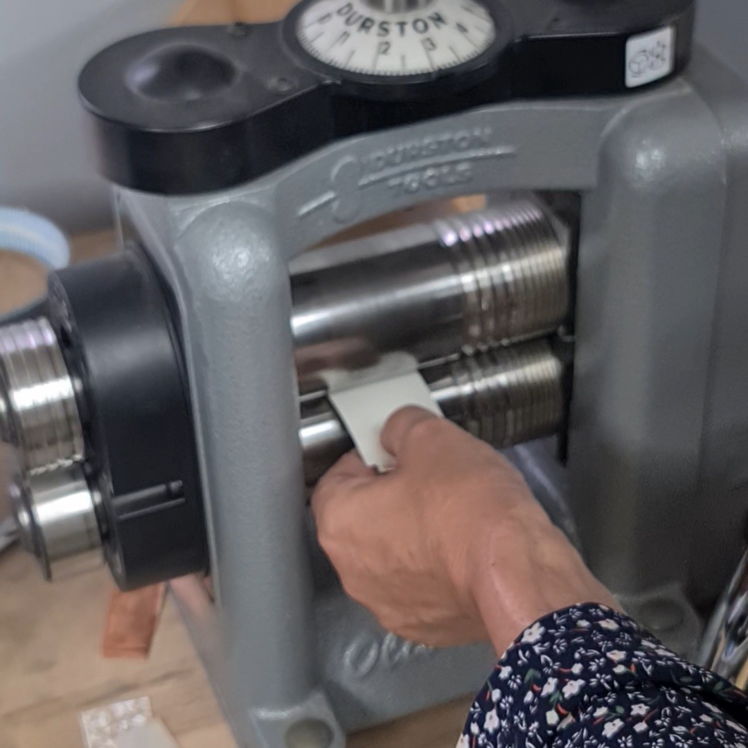 roll the texturing sandwich through the rolling mill to texture the metal